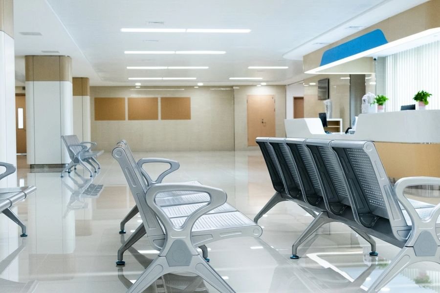 Empty hospital waiting room, chairs in a row, fluorescent light