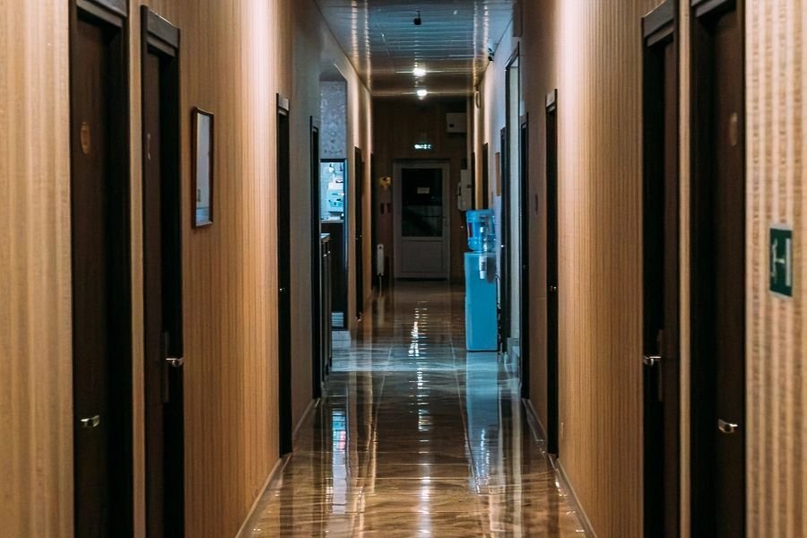 Hotel corridor stretching into distance, identical doors