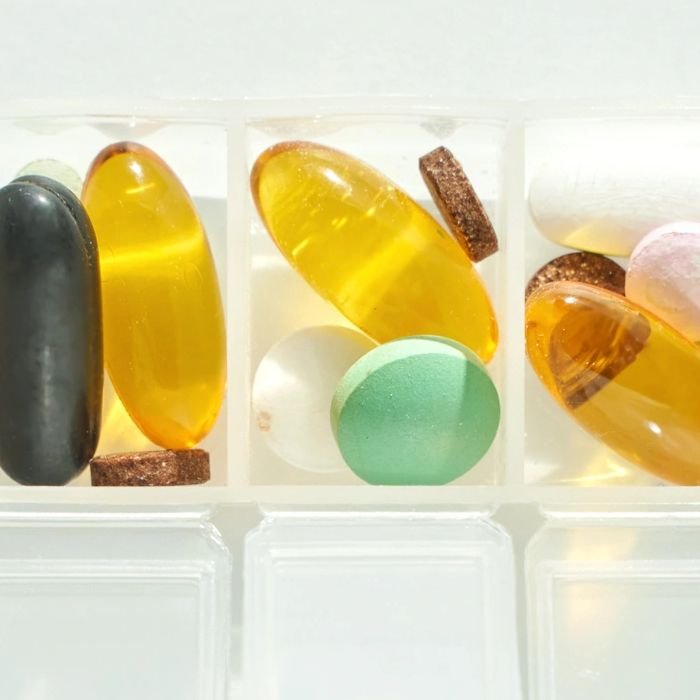 Pill organizer on windowsill, morning light, seven compartments