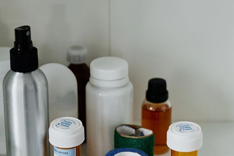 Prescription bottles arranged by height on bathroom shelf