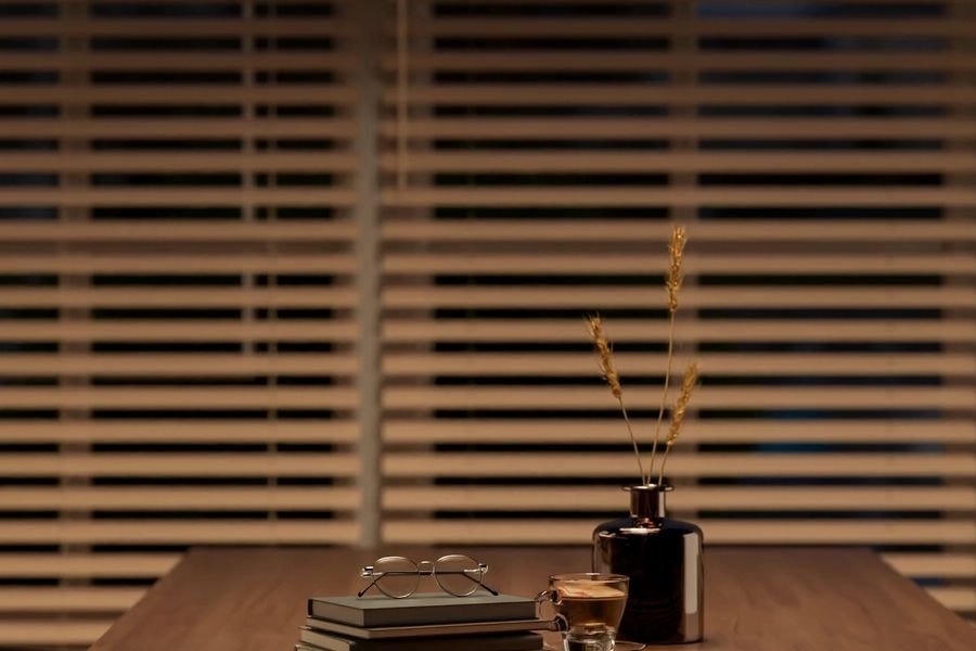 Kitchen table with open book, single lamp, dark window